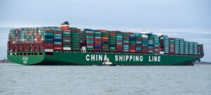 A massive container ship -- with large containers on the deck stacked in neat stacks of ten.