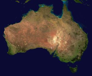 A satellite image of Australis shows that most of it looks either brown on yellow from space, other than some light green areas near the coast on all sides. 