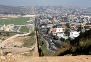 On the left, fields and dirt. In the middle, a straight fence to the horizon. On the right, the dense urban core of Tijuana, Mexico. 